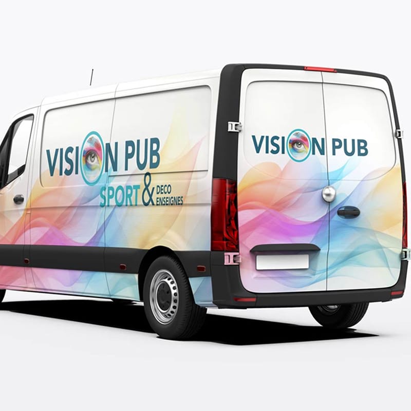 Van blanc personnalisé avec un covering coloré. Logo 'VISION PUB' avec œil, texte 'SPORT & DECO ENSEIGNES' visible.