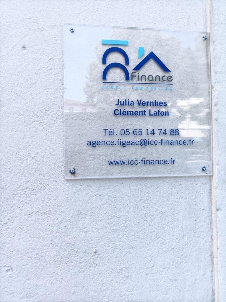 Panneau ICC Finance Crédit Immobilier avec noms Julia Vernhes, Clément Lafon, tél. 05 65 14 74 88, email agence.figeac@icc-finance.fr et site www.icc-finance.fr.