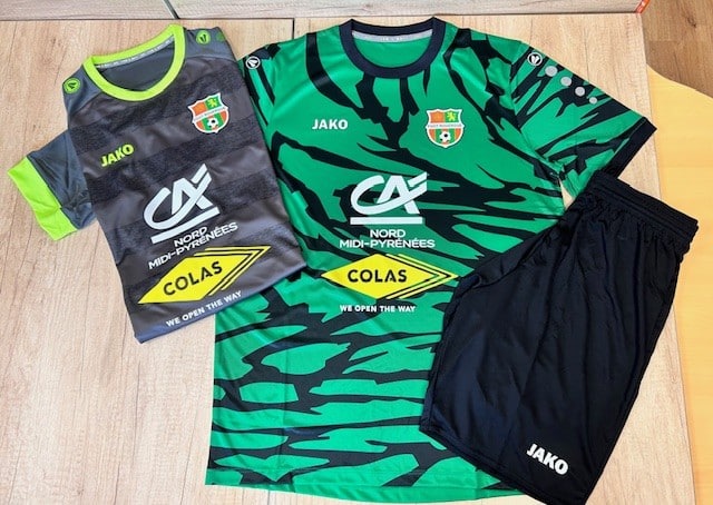 Deux maillots de football Jako (gris/néon, vert/noir) et shorts noirs, posés. Logos Crédit Agricole Nord Midi-Pyrénées, Colas et écusson Foot Montaigu.