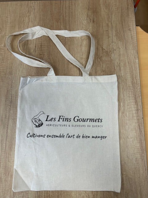 Sac cabas blanc 'Les Fins Gourmets', logo canard, 'Agriculteurs & Éleveurs du Quercy'. Slogan: 'Cultivons l'art de bien manger'.